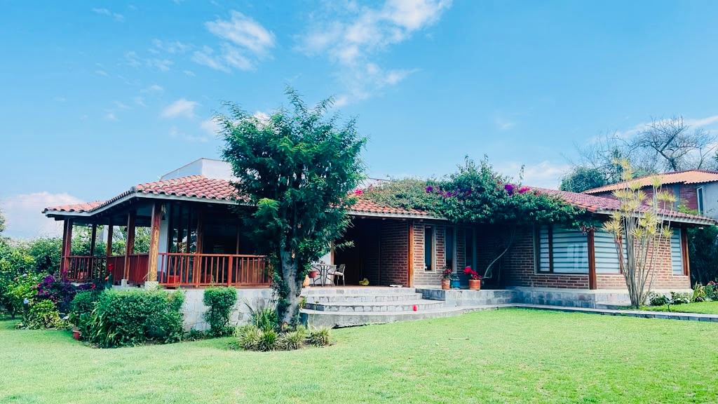 Fachada de la Casa Sr. Ricardo Gangotena con cubierta de teja y jardín